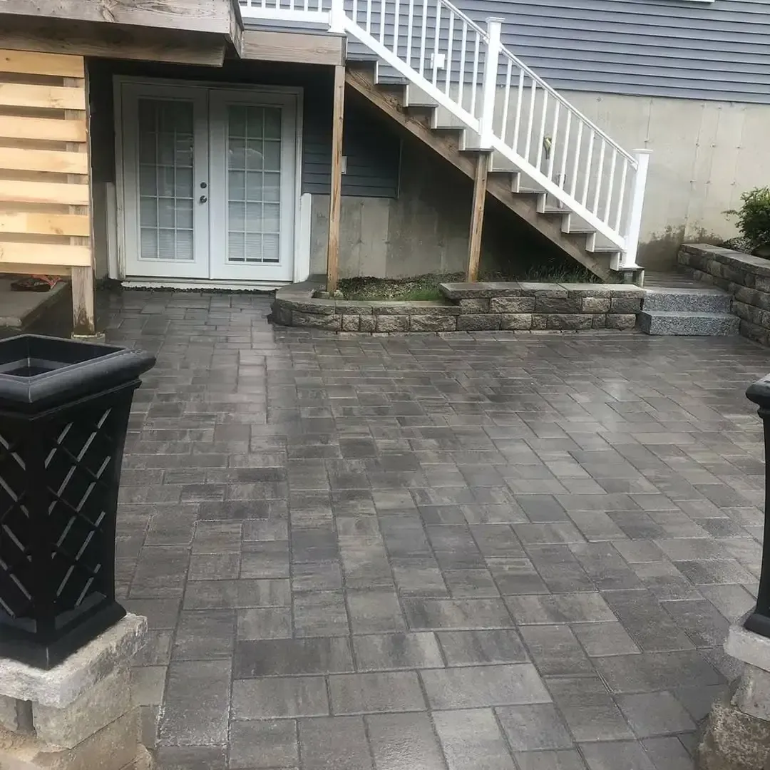 A brick patio with stairs leading up to a house.