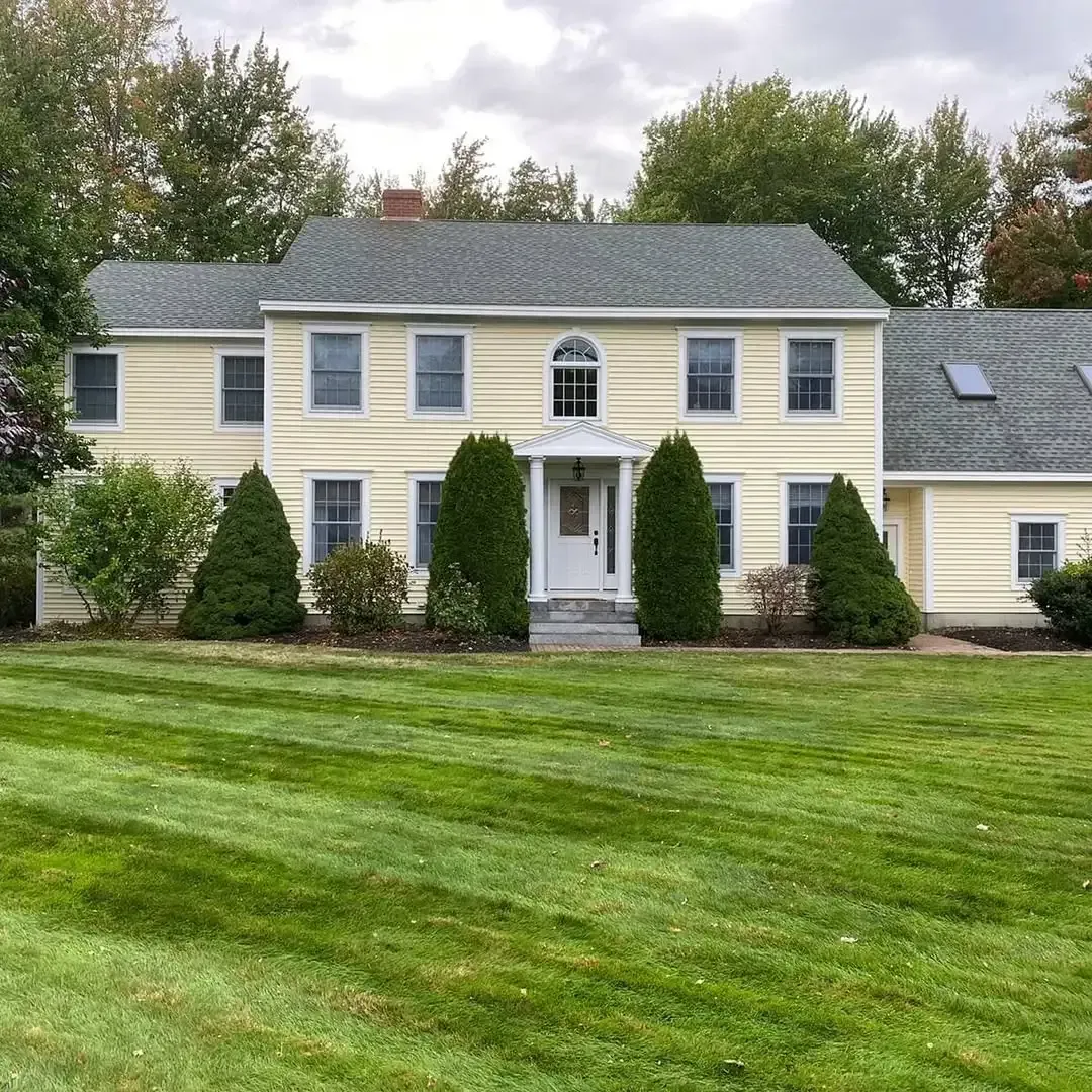 A large house with a lush green lawn in front of it.