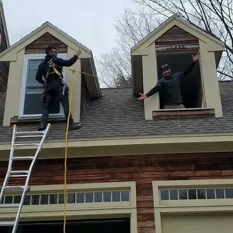 Two men are working on the roof of a house.
