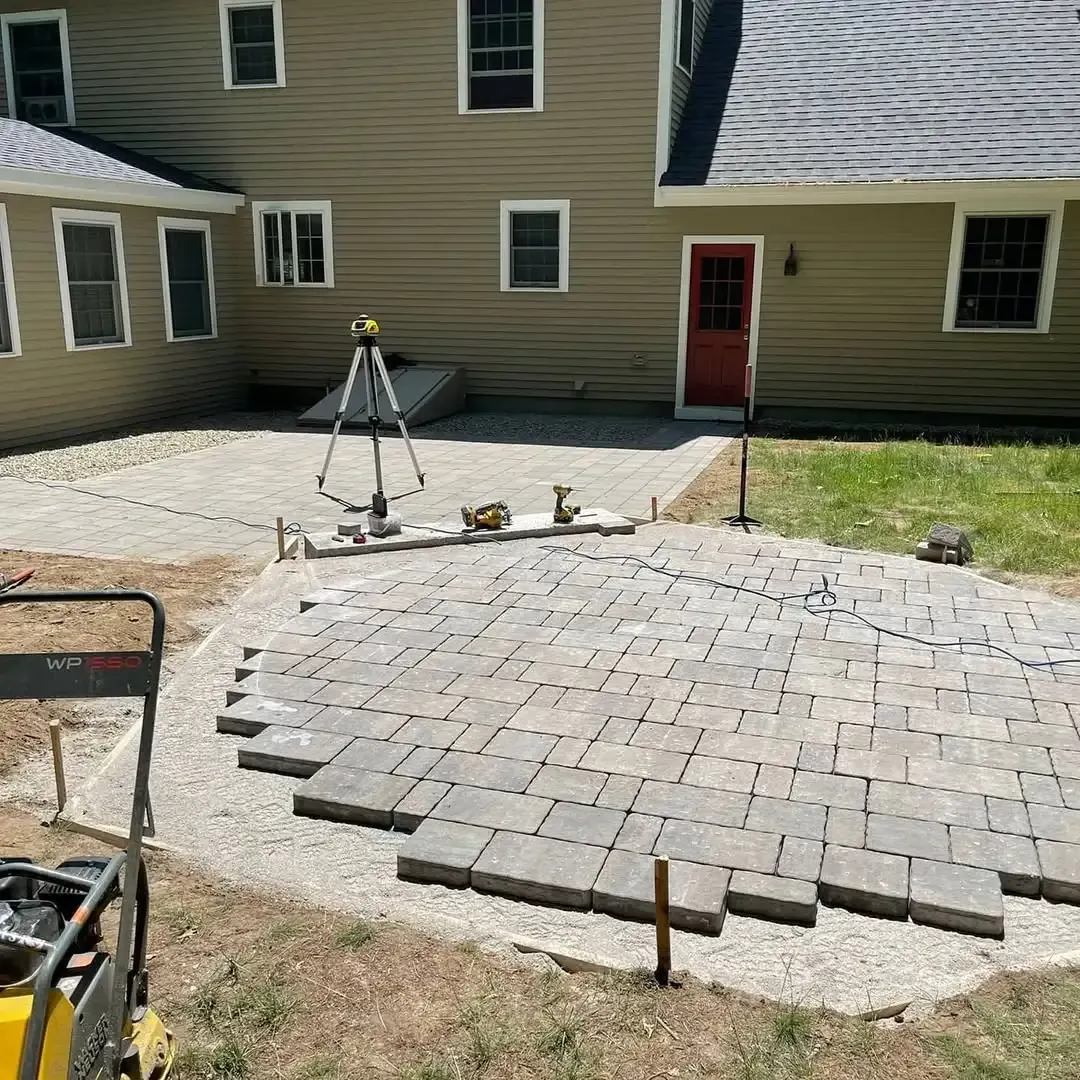 A patio is being built in front of a house.