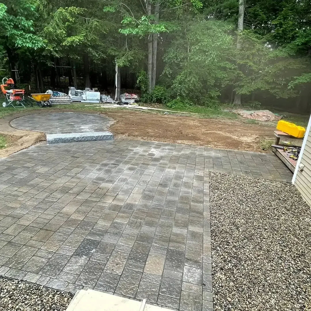 A patio is being built in the backyard of a house.