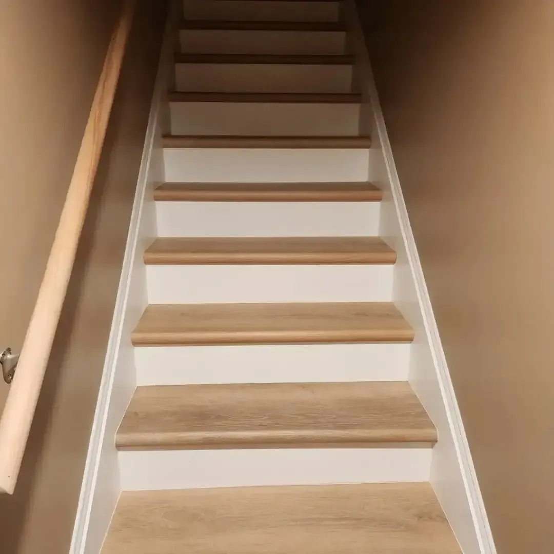 A set of stairs with wooden steps and a white railing