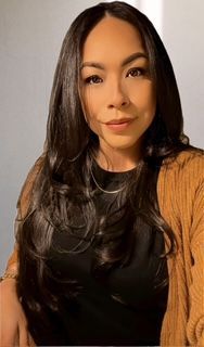 Palm trees silhouetted against a sunset over a calm ocean.