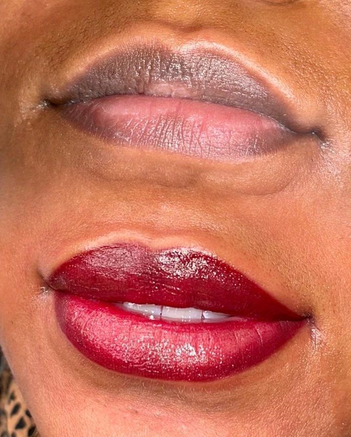 makeup artist applying red lipstick to woman