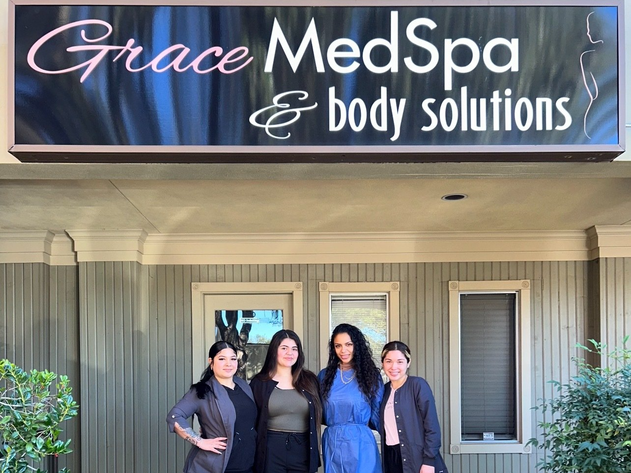 Four women standing in front of a building with a