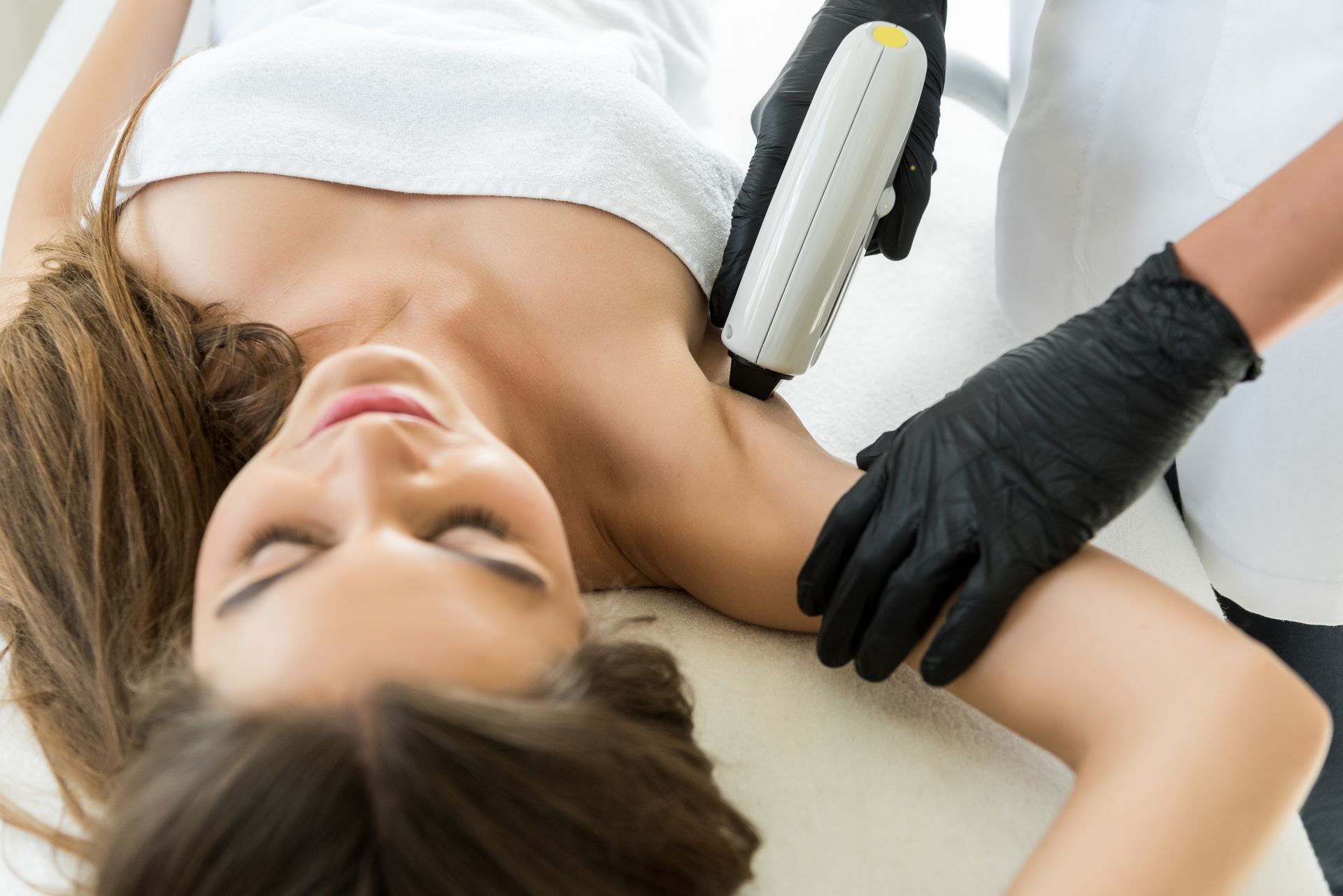 a woman is getting a laser hair removal treatment on her armpit .