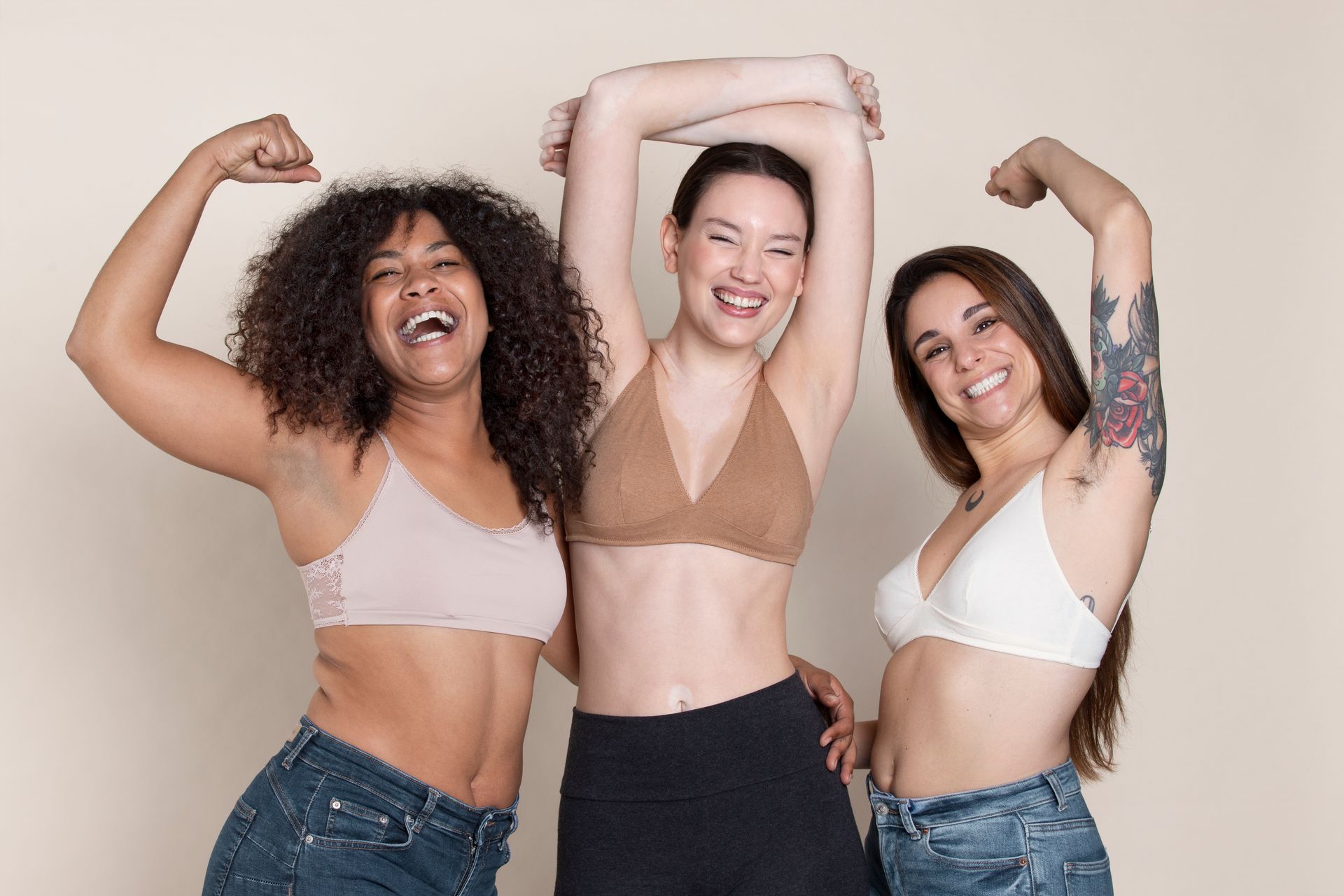three women are posing for a picture together and flexing their muscles .