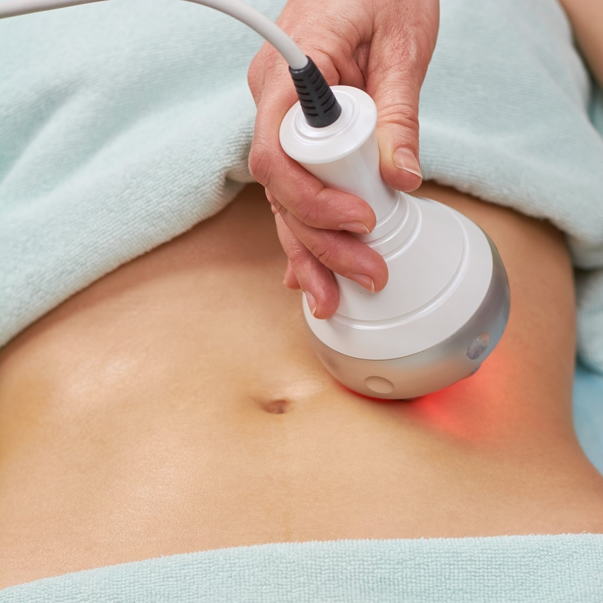 a woman is getting a cavitation treatment on her stomach