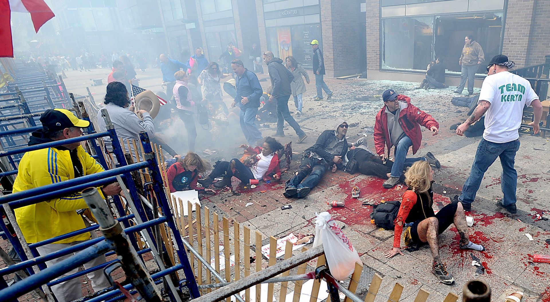 Smoke hovers over a chaotic scene of injured people and spectators along Boylston Street in Boston, just yards from the Boston Marathon finish line, after a bombing on April 15, 2013.