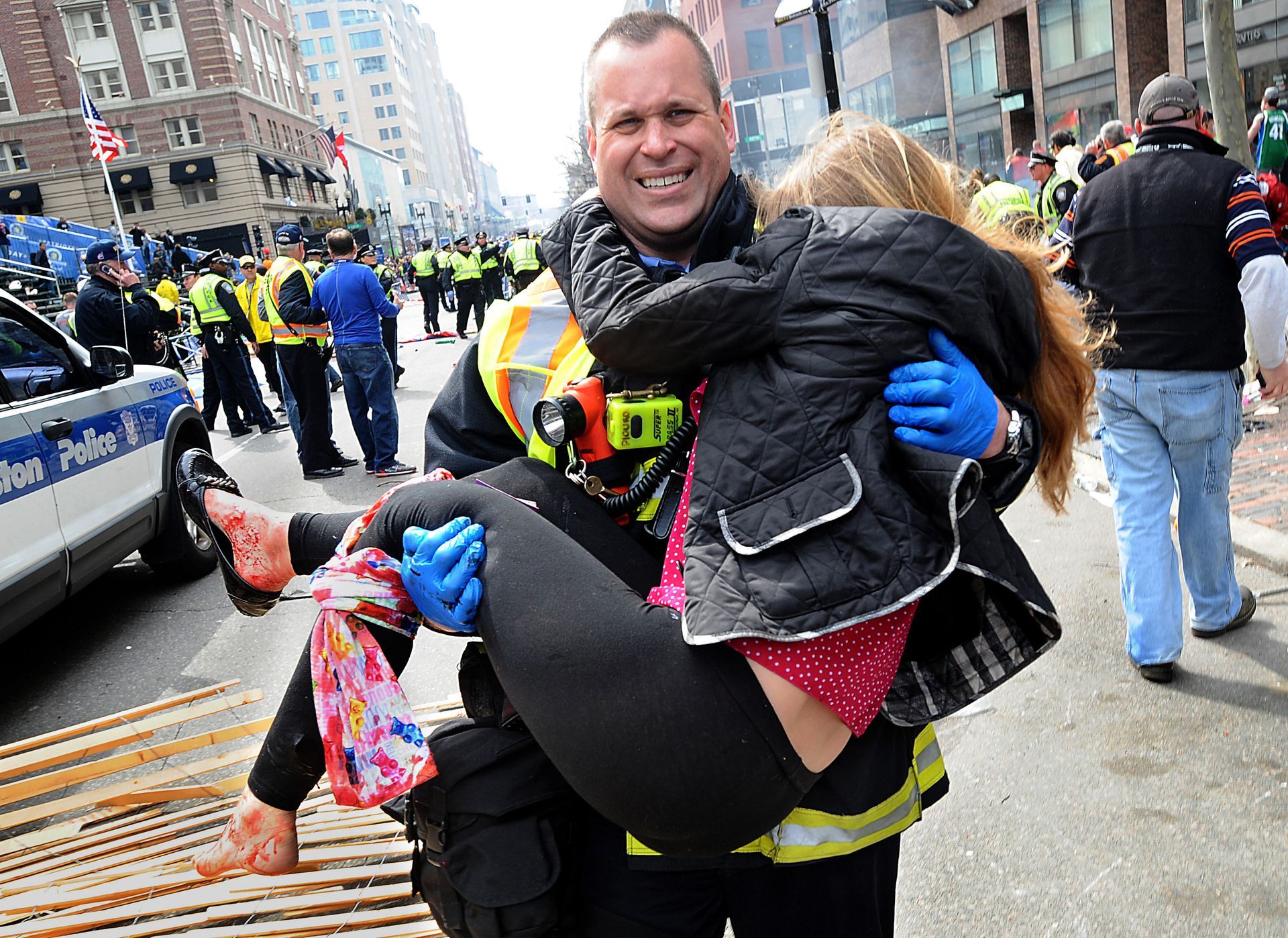 Boston Firefighter James Plourde carries Victoria McGrath, 20, an injured spectator, from the scene of the Boston Marathon bombing on Boylston Street on Monday, April 16, 2013.