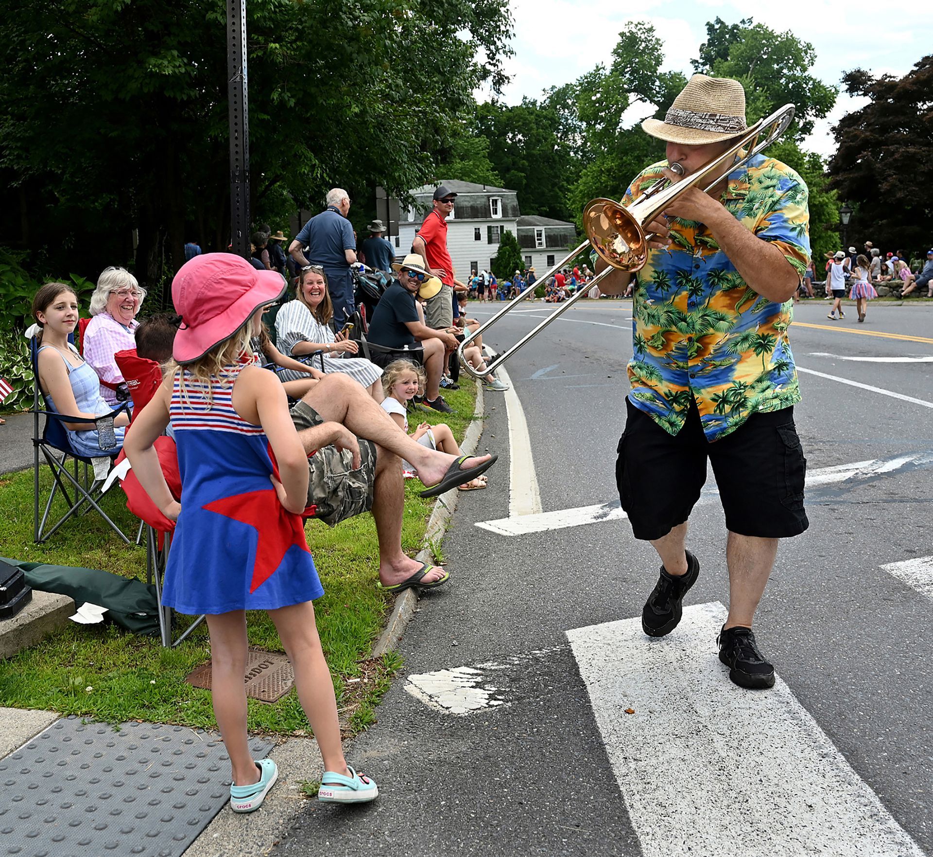 Trombone player Steve Curtis of the New Magnolia Jazz Band serenades a youngster during the Sudbury Fourth of July parade, July 4, 2022.