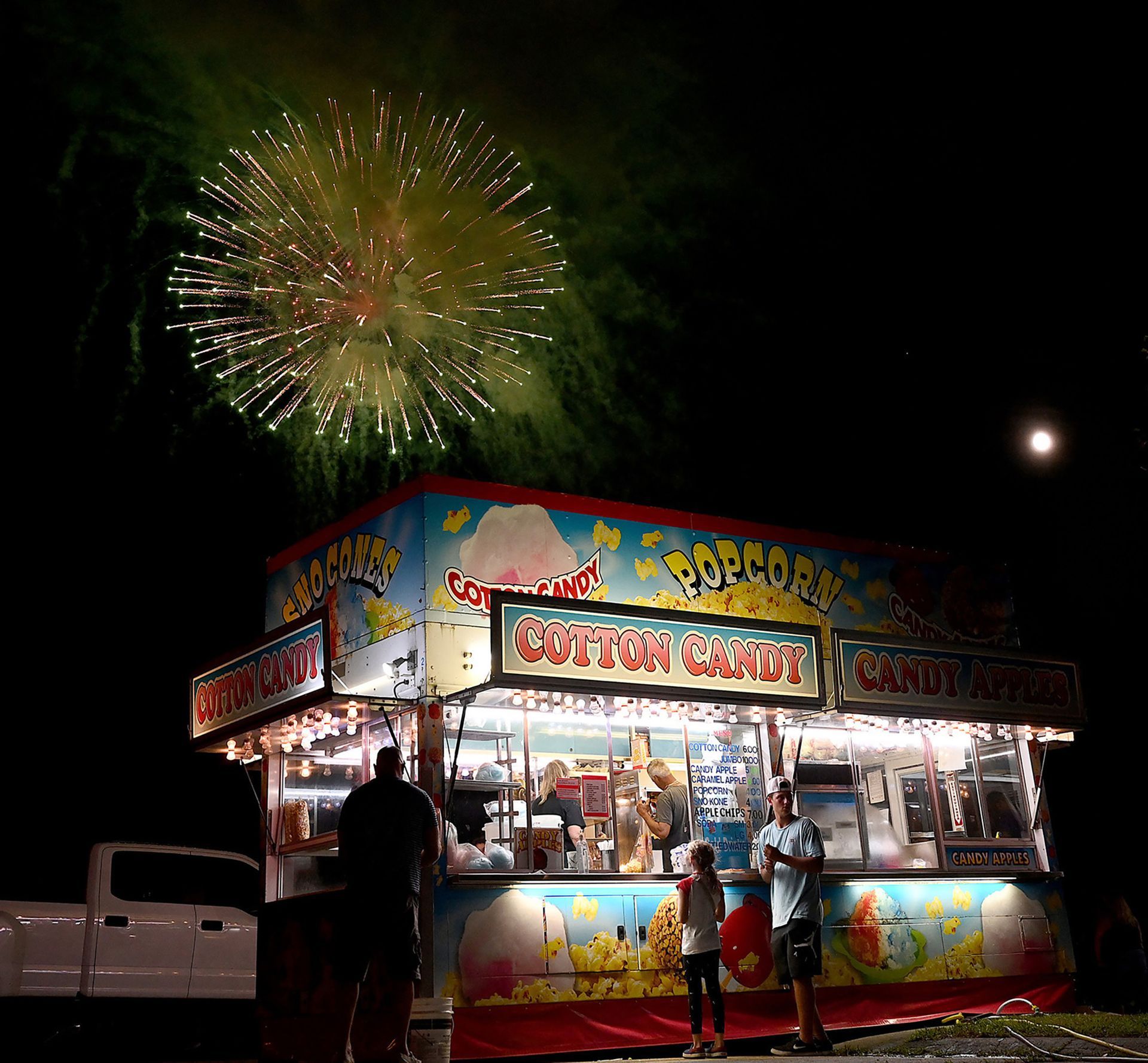 Fireworks rise above the cotton candy booth during Bellingham Days at Bellingham Middle School, August 21, 2021.