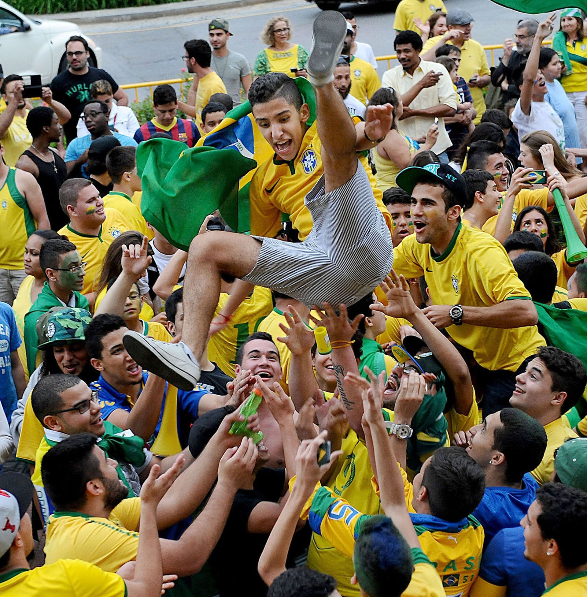 Jubilant Brazil soccer fans in downtown Framingham body surf after an opening round World Cup victory over Croatia, June 12, 2014.