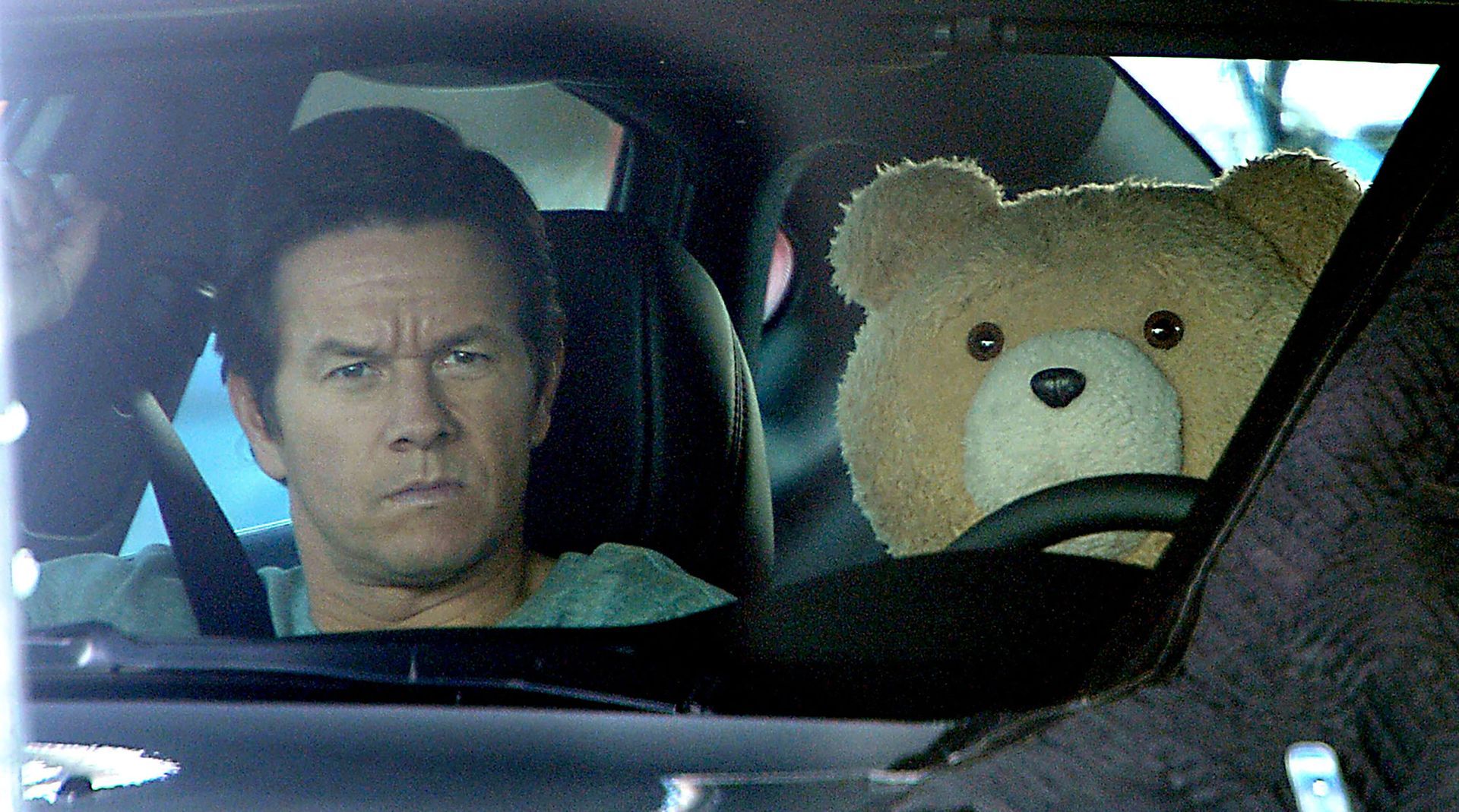 Actor Mark Wahlberg, star of “Ted 2”, waits in the car with Ted at the Framingham Plaza to film a scene on the Mass Pike, Aug. 14, 2014.