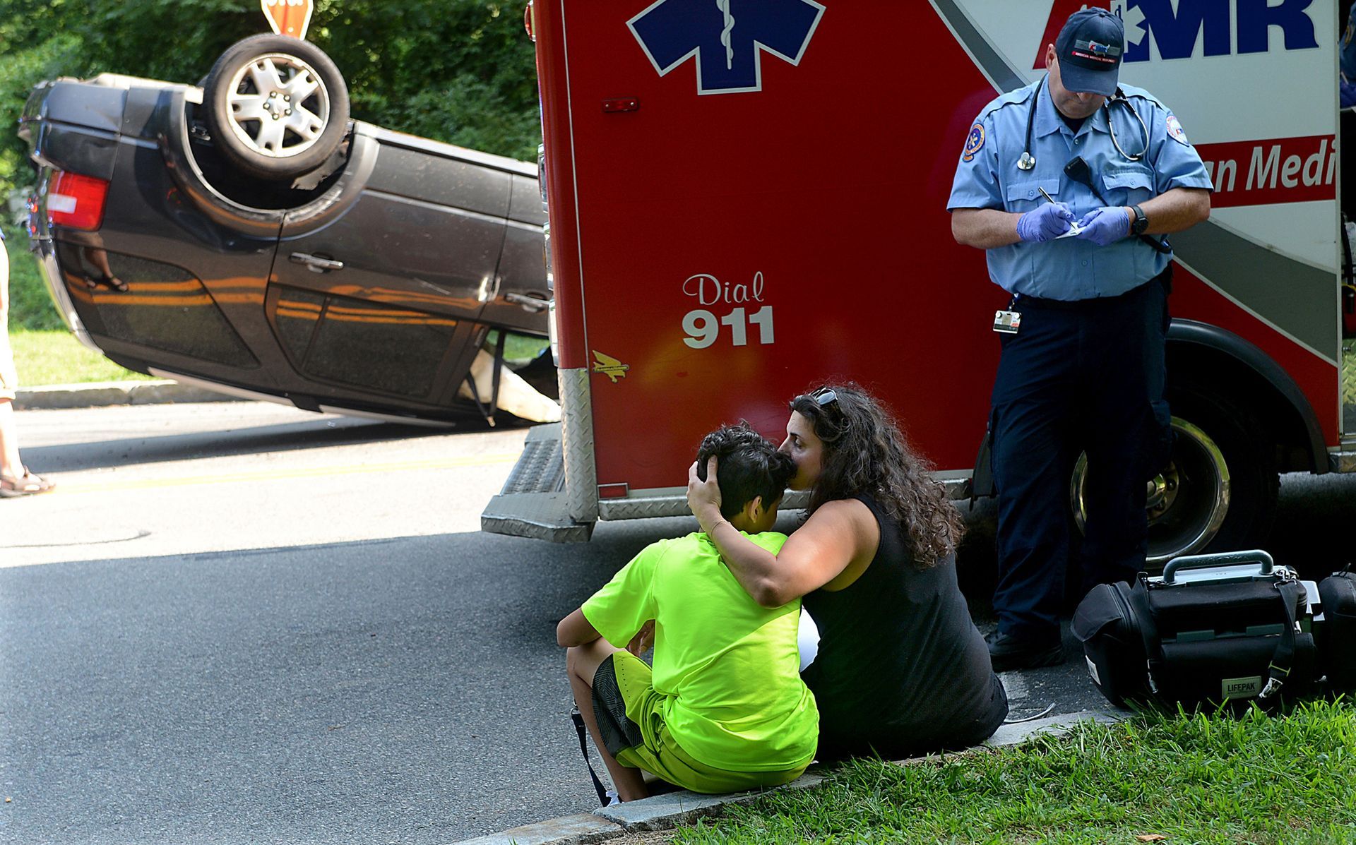 Lilla Martell of Framingham kisses her son, Joseph, 14, after her Ford Freestyle SUV rolled over following a two-car crash with another SUV on August 16, 2017.