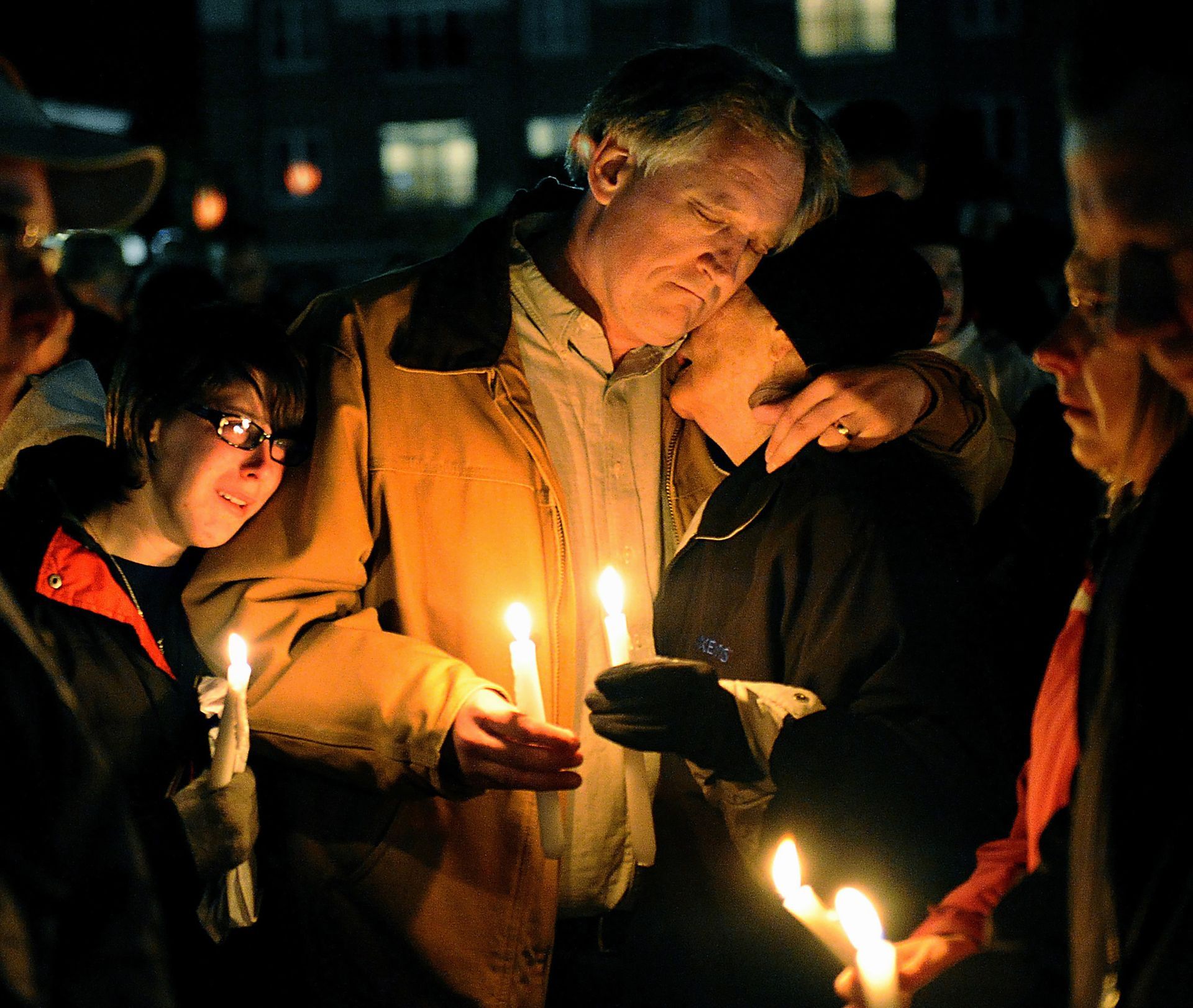 Bob Marriott, center, the father of murder victim Elizabeth Marriott, 19, hugs a family friend during candlelight vigil in memory of his daughter at the Bay State Commons in Westborough, Oct. 13, 2012.