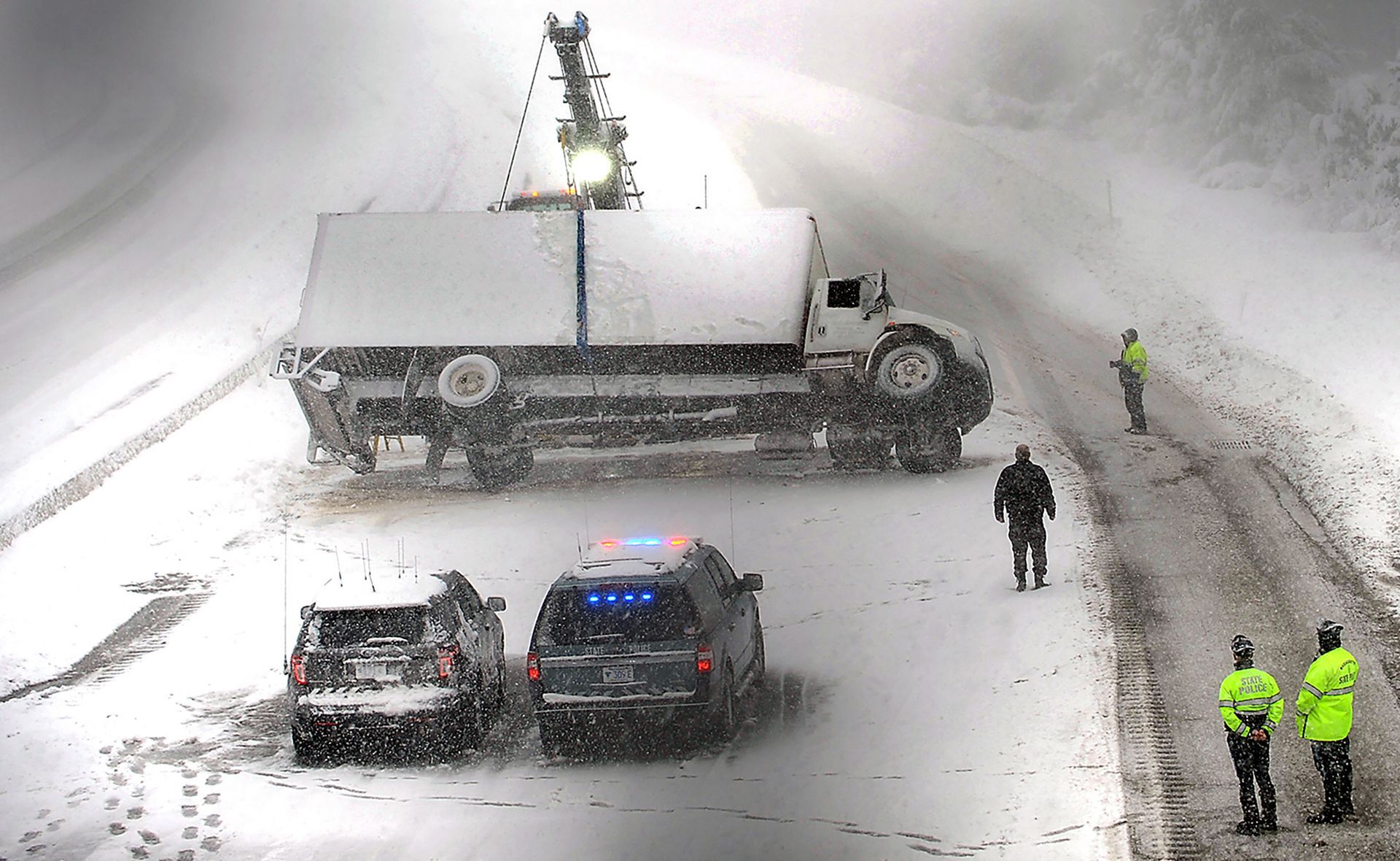 A large box truck is righted after rolling over on the Mass Pike eastbound in Framingham during a blizzard on March 13, 2018.