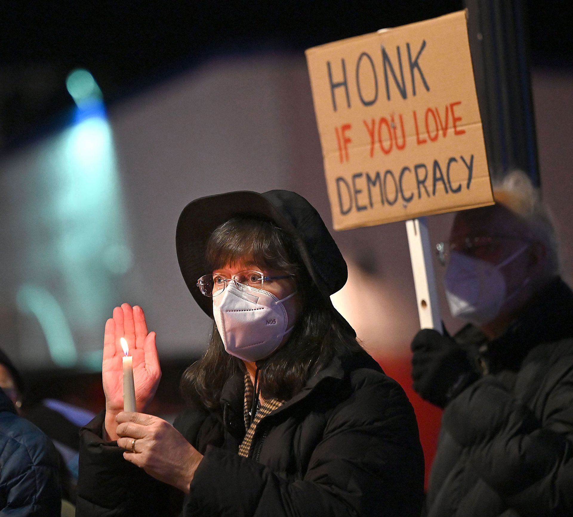 Amy Groves of Ashland holds a candle during a Vigil for Democracy, held on the first anniversary of the Jan 6, 2021 attack on the U.S. Capitol, in downtown Framingham, Massachusetts, Jan. 6, 2022.