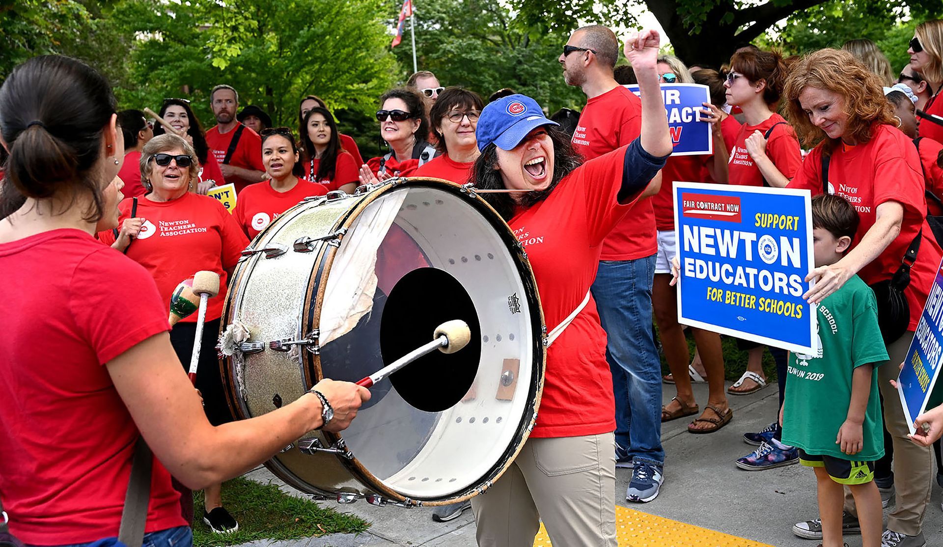 Jaime Alberts, center, a music teacher at the Bigelow Middle School, bangs a marching band drum during the Newton Teachers Association's protest of unresolved contract negotiations at City Hall Wednesday morning, August 28, 2019.