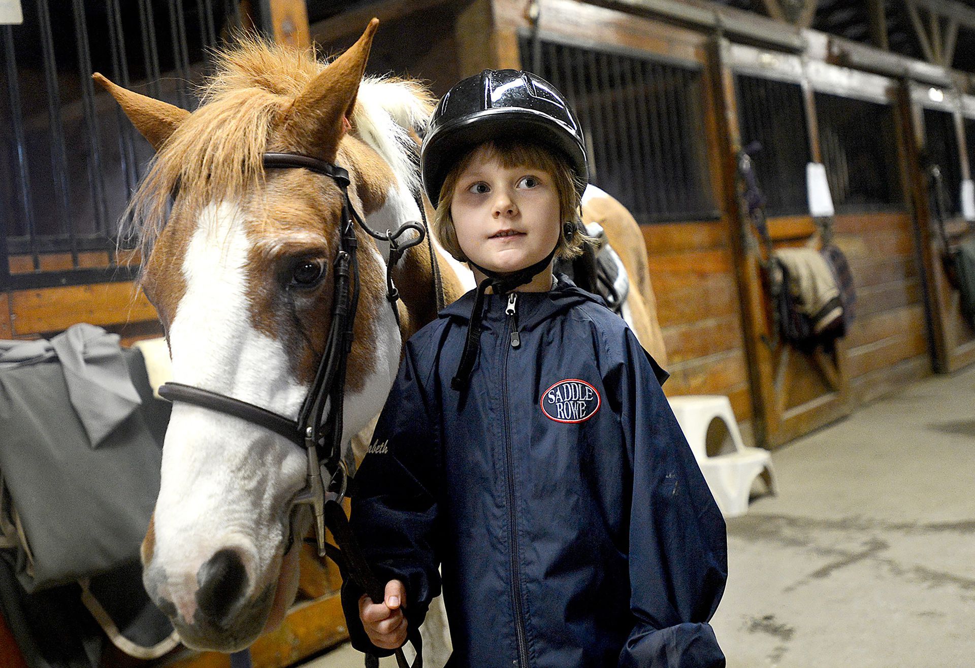 Elizabeth Ouimet, 6, of Sherborn, and Tootsie prepare to leave the Saddle Rowe equestrian center barn for a horseback riding lesson during the first annual Horse 'N Harvest Saturday, October 22, 2016.