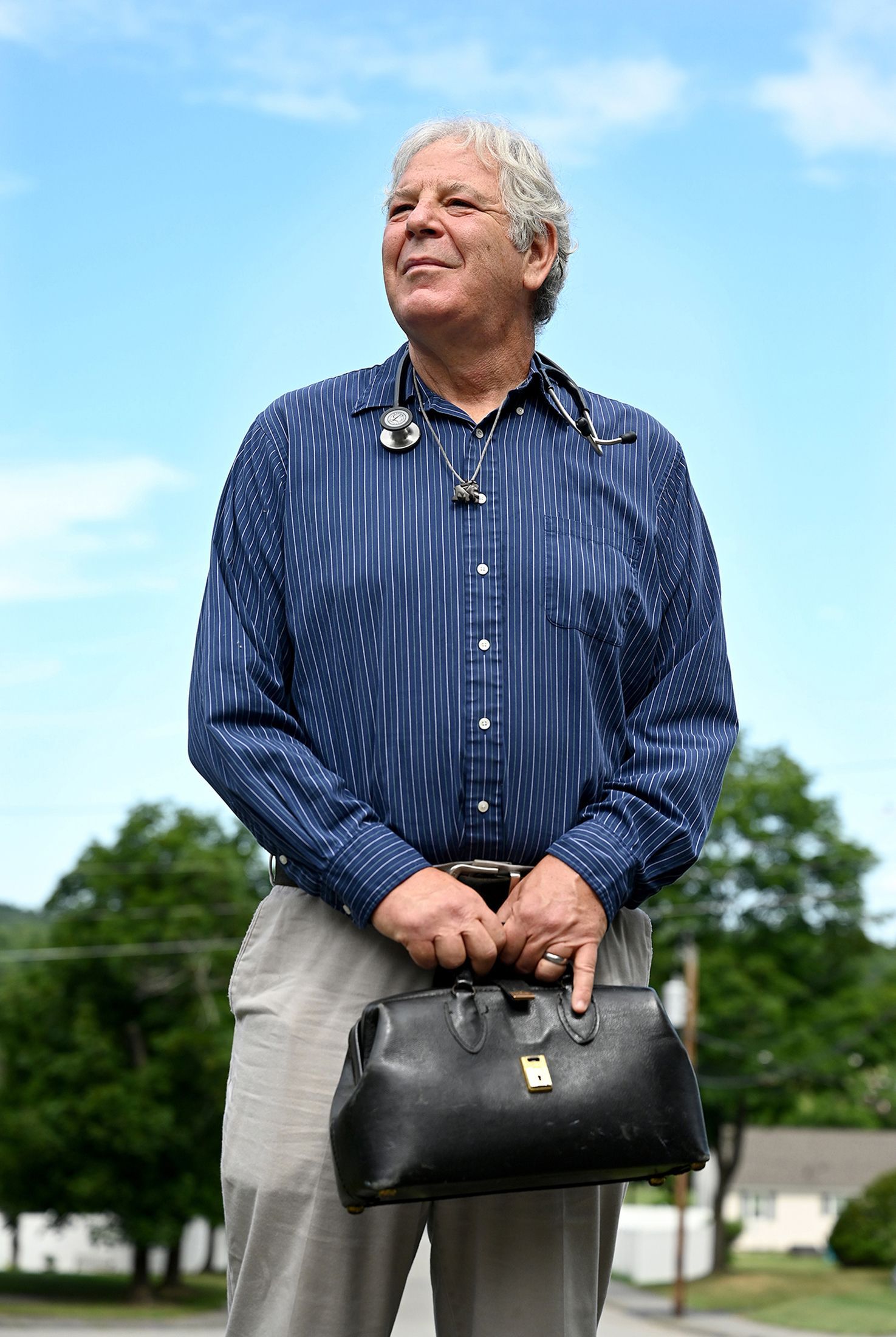 Dr. Brian Lisse holds his well-worn black bag outside his Hudson, Massachusetts home on July 8, 2022. Dr. Lisse and the bag will be traveling later in the month to Przemysl, Poland, to render medical aid to Ukranian refugees.