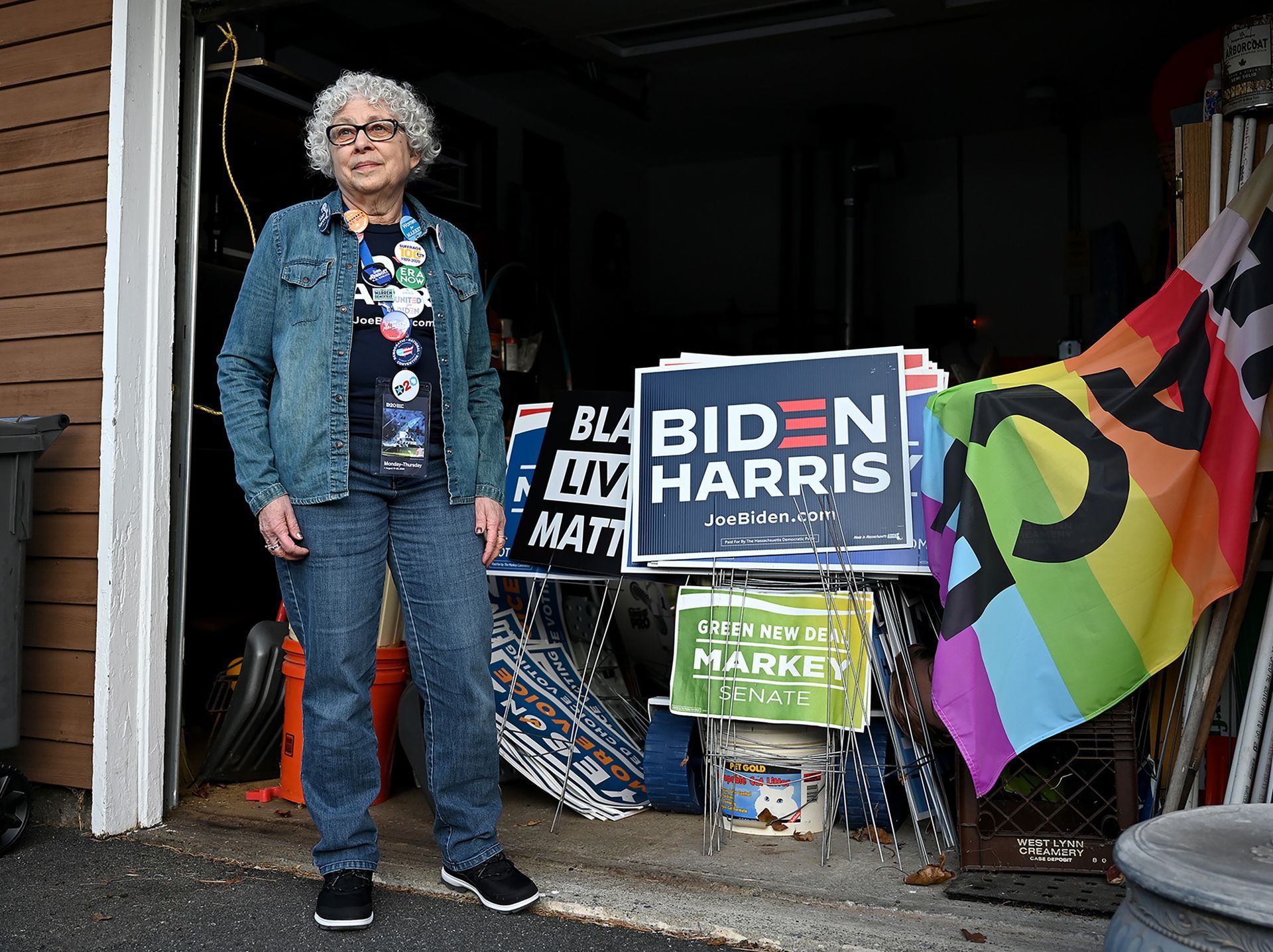 Norma Shulman, one of eleven Massachusetts electors who will cast votes for President-elect Joe Biden and Vice President-elect Kamala Harris, poses amidst Biden/Harris and Black Lives Matters signs in her Framingham garage, Friday, Dec. 11, 2020.