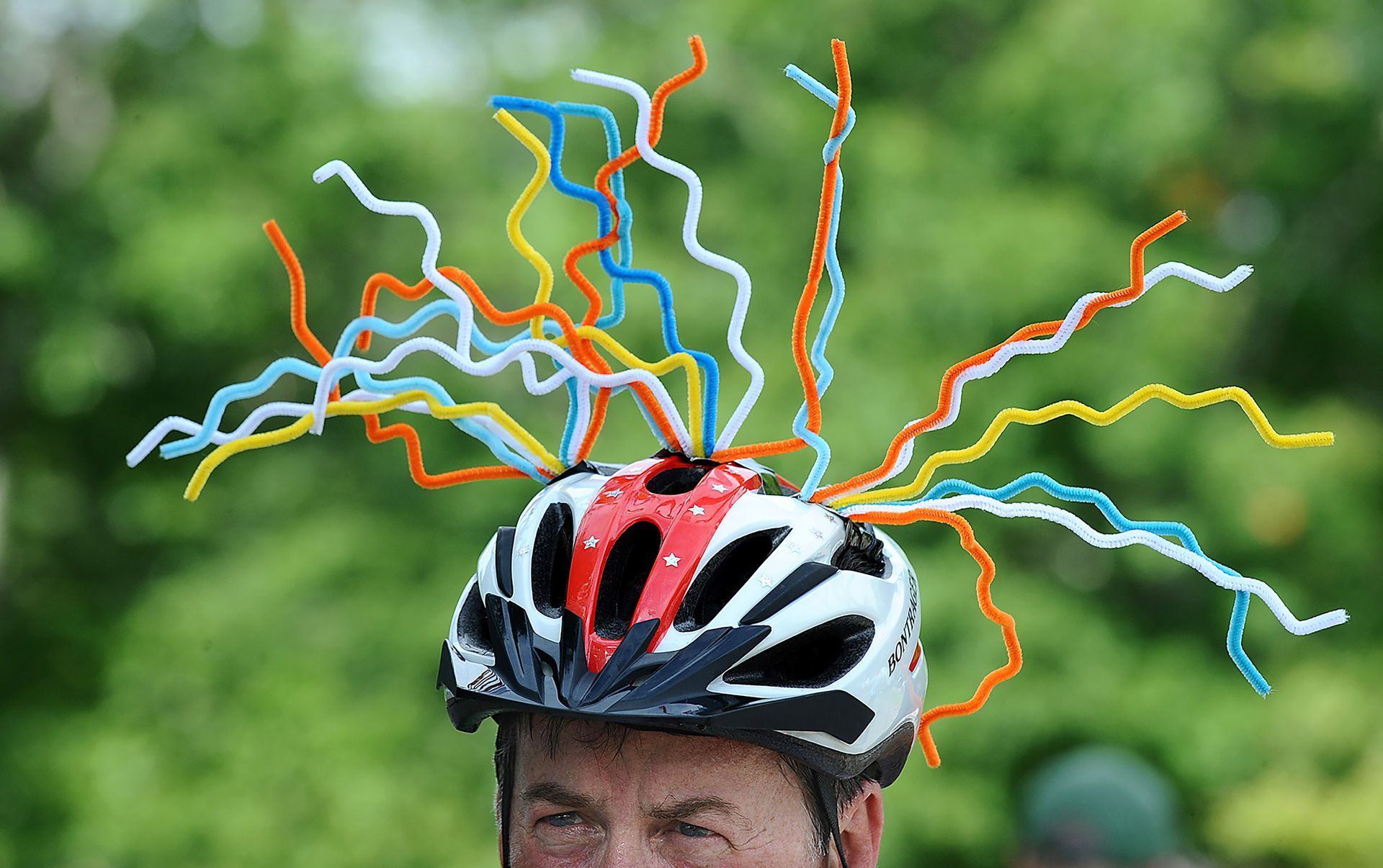 Cyclist Paul Meng of Chantilly, Virginia, stands out in his helmet headdress at a water stop in Franklin, Massachusetts, during the Pan-Mass Challenge, an annual bike-a-thon fundraiser for cancer research, on Saturday, August 4.