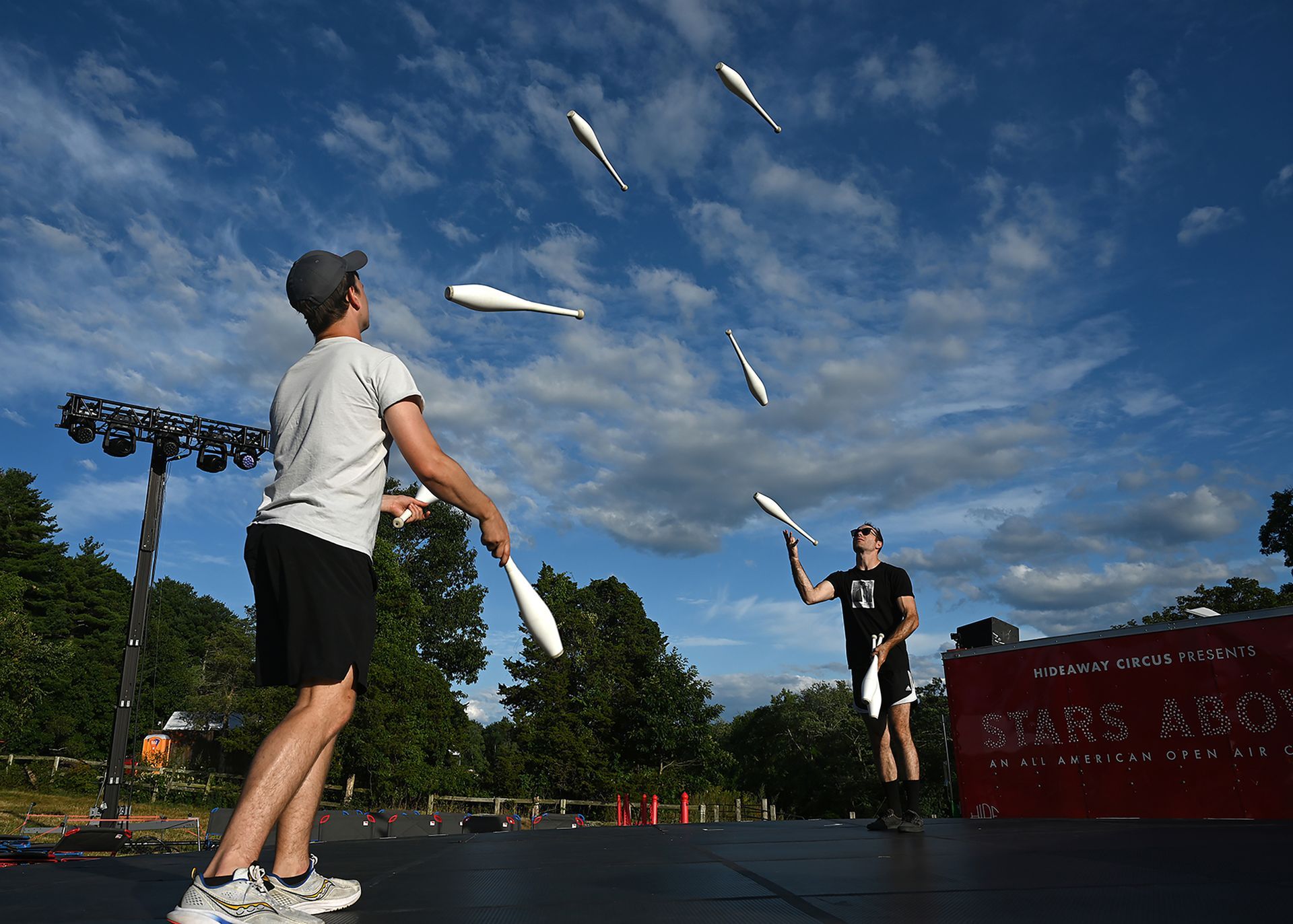 Jugglers Aaron Dewitt and Willem McGowan warm up before an evening performance of Stars Above, an open-air circus, at Eastleigh Farm in Framingham, August 12, 2022.
