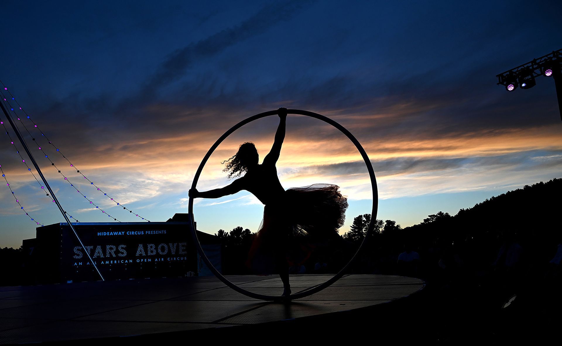 Julia Ruth performs on the cyr wheel as the sun sets at Eastleigh Farm in Framingham during an evening performance of the Stars Above open-air circus , August 12, 2022.