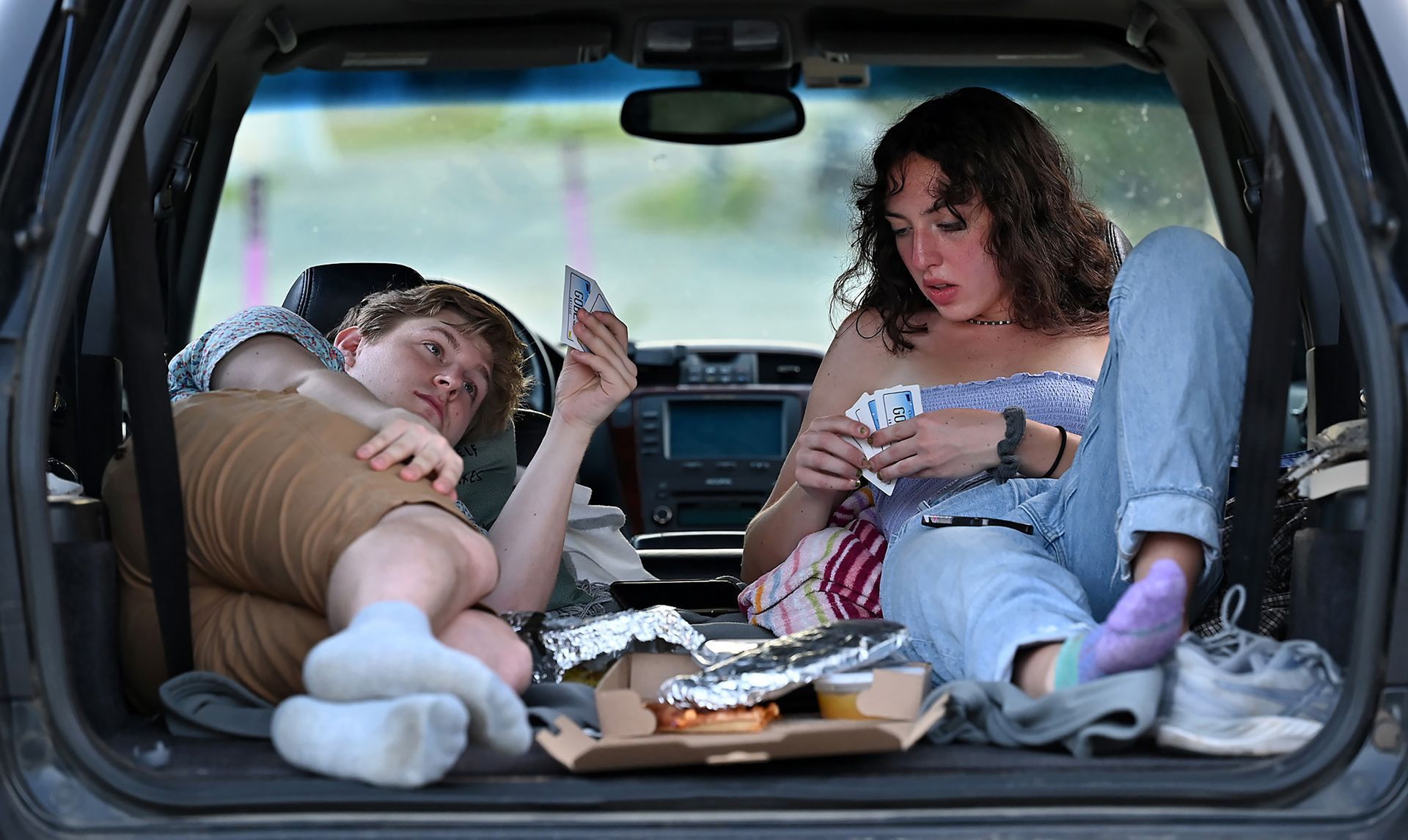 College students Sarah Wille of Lexington, right, and Curtis Rogers of Powhatan, Virginia, play cards while waiting for a showing of the cowboys and aliens monster movie