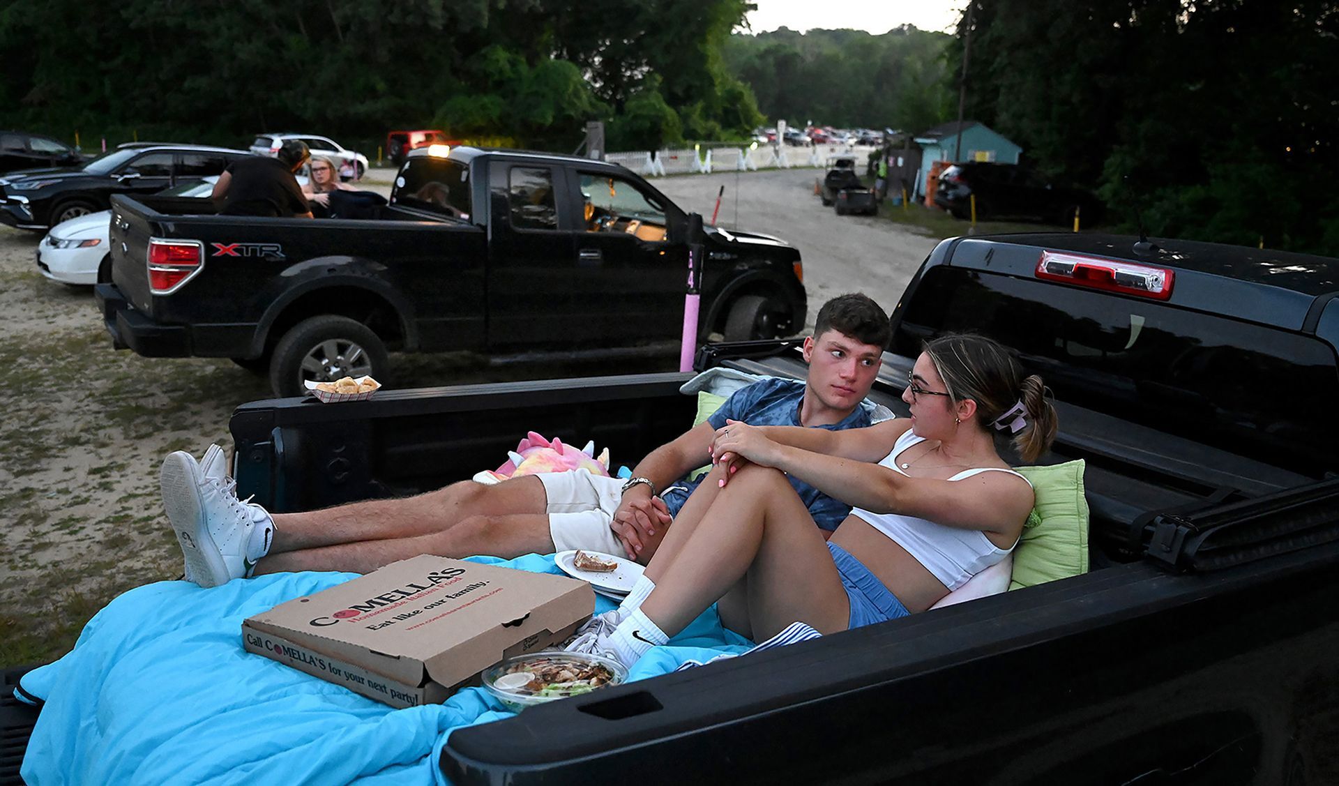 Tyler Marshall of Needham and Caroline Davey of Norwood, 19, pass the time while waiting for an opening night showing of the cowboys and aliens monster movie