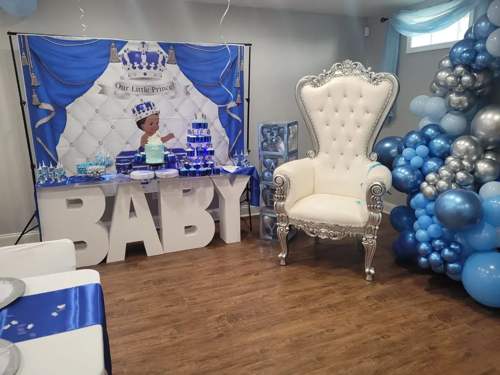 a room decorated for a baby shower with balloons and a chair .