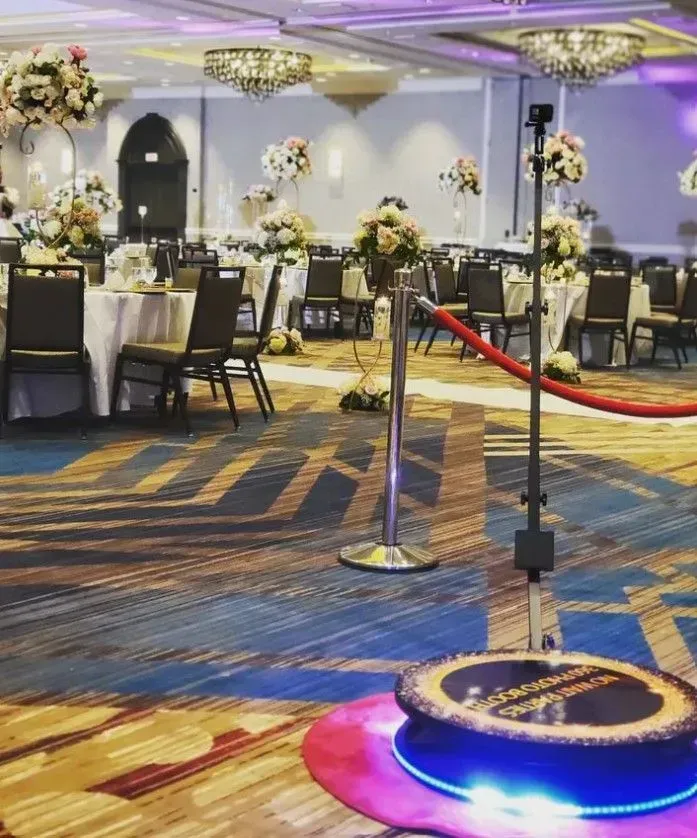 a large room with tables and chairs and a red rope .