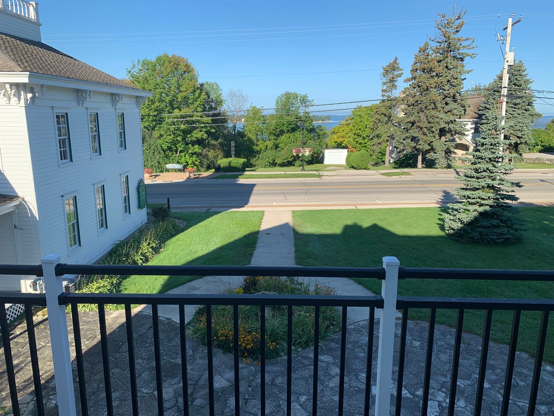 A view of a house from a balcony with a black railing.