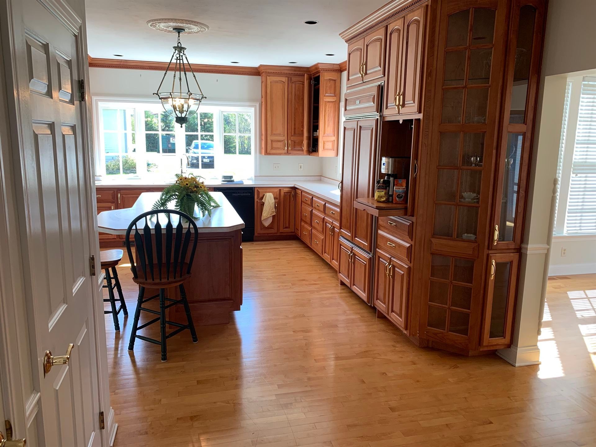 A kitchen with wooden cabinets and a large island.