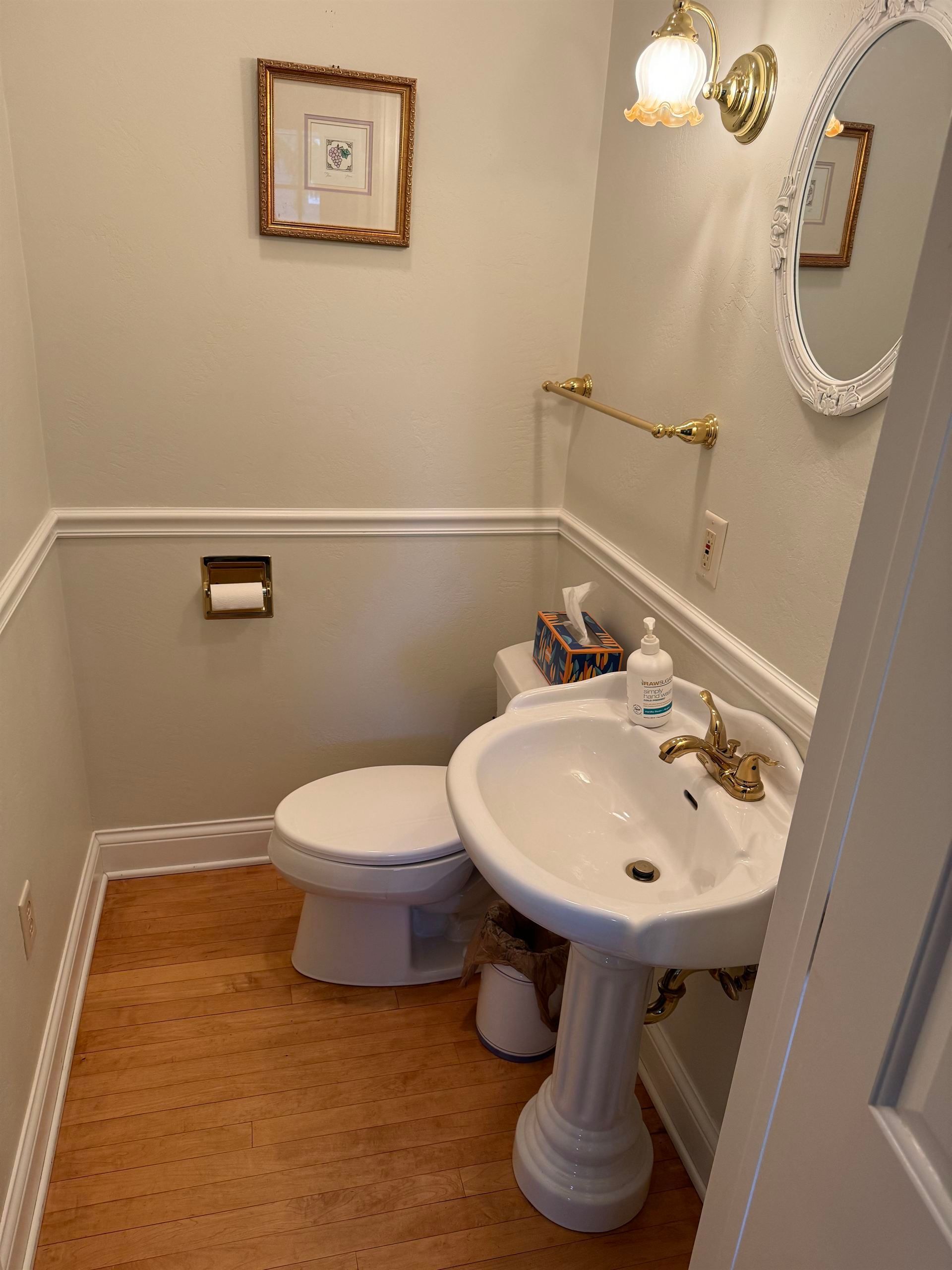 A bathroom with a toilet a sink and a mirror