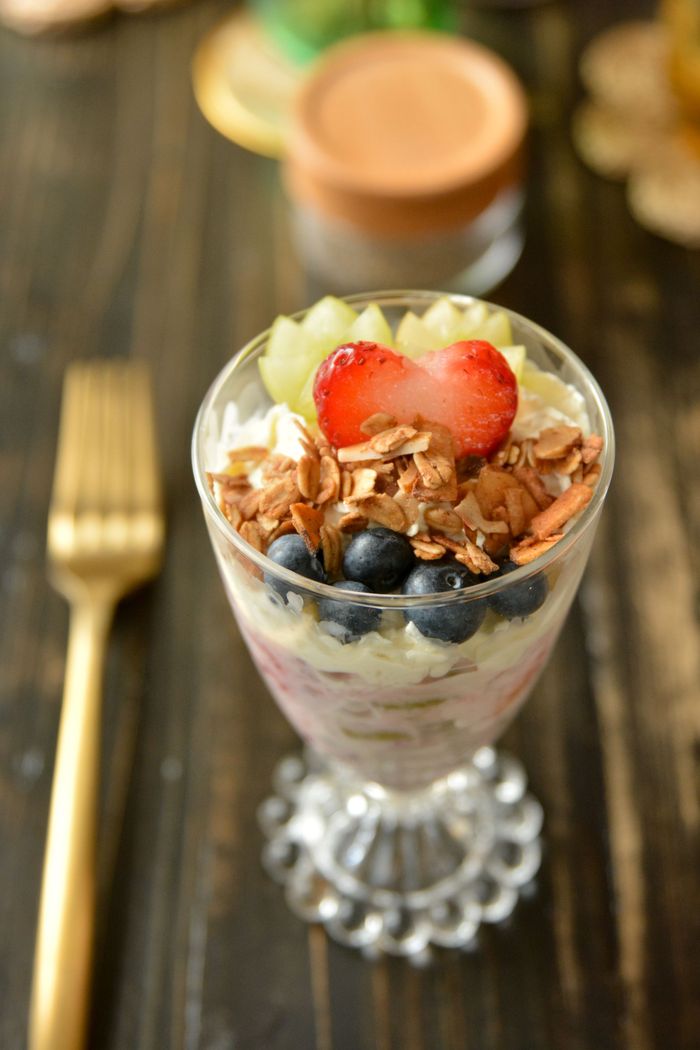 Fruit salad in a glass container with a strawberry heart on top