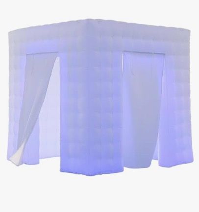 An illuminated, inflatable photo booth with white walls and curtains.