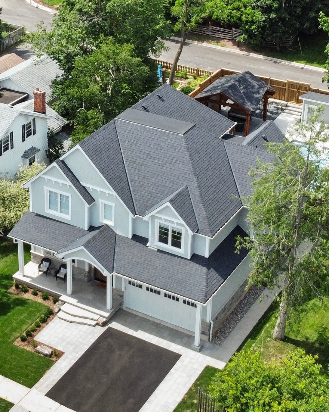 An aerial view of a large white house with a black roof