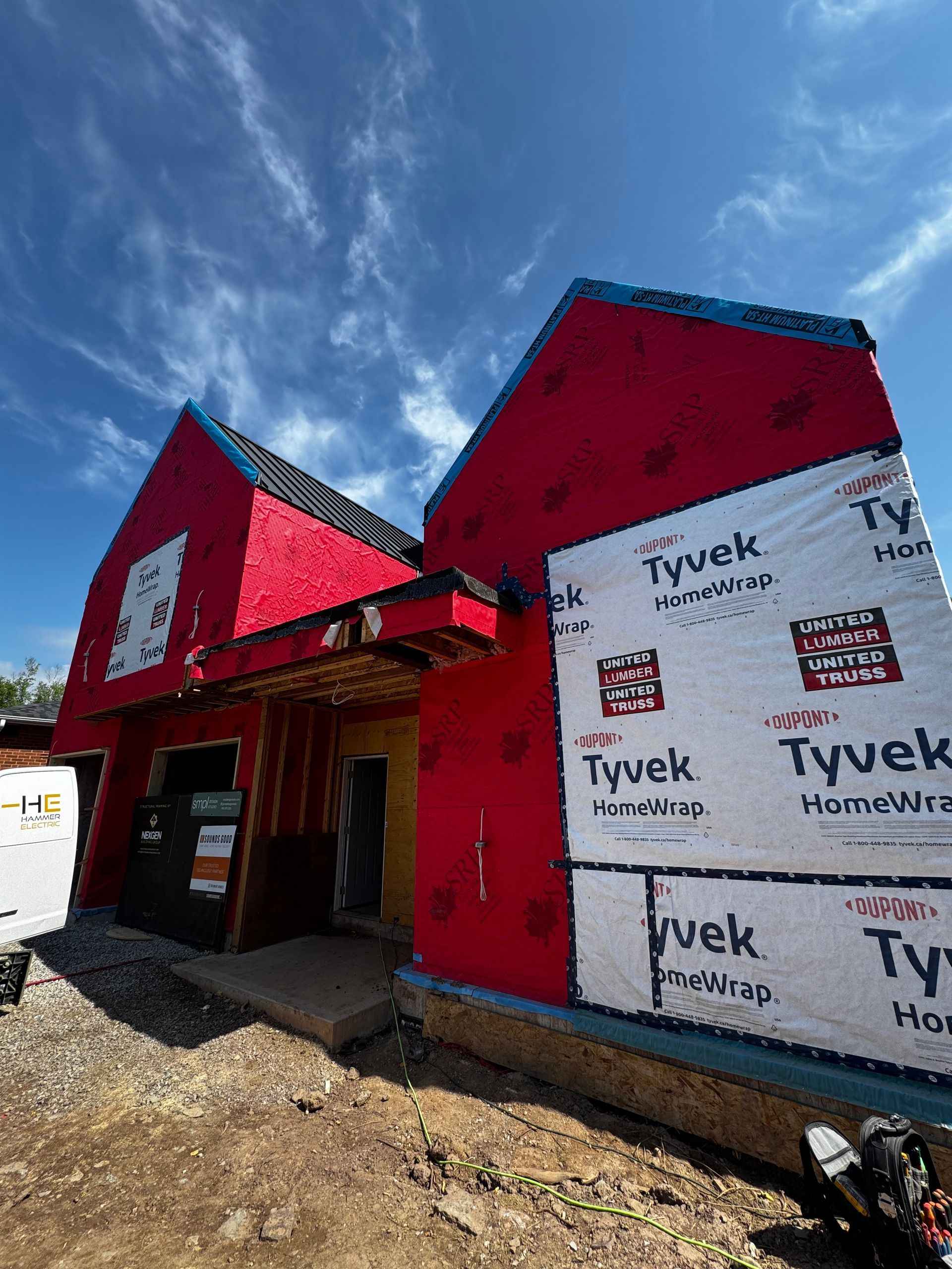 A red house with a blue roof is being built.