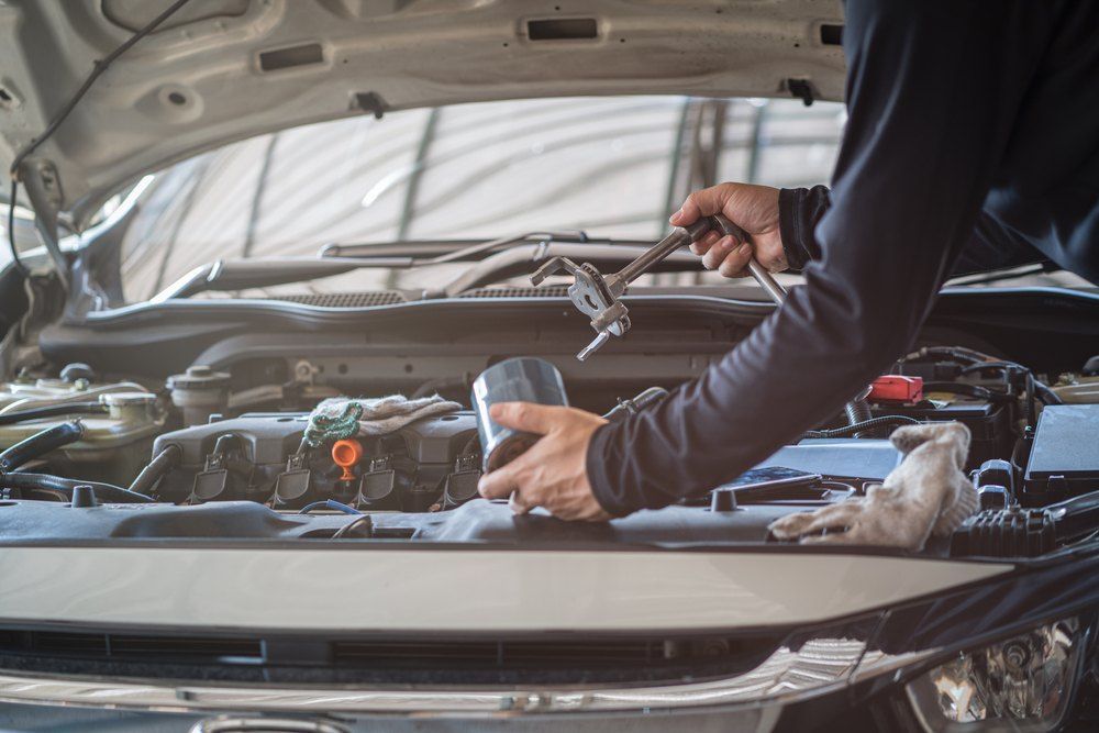 A Man is Working on the Engine With a Wrench — All Mechanical Services in South Murwillumbah, NSW