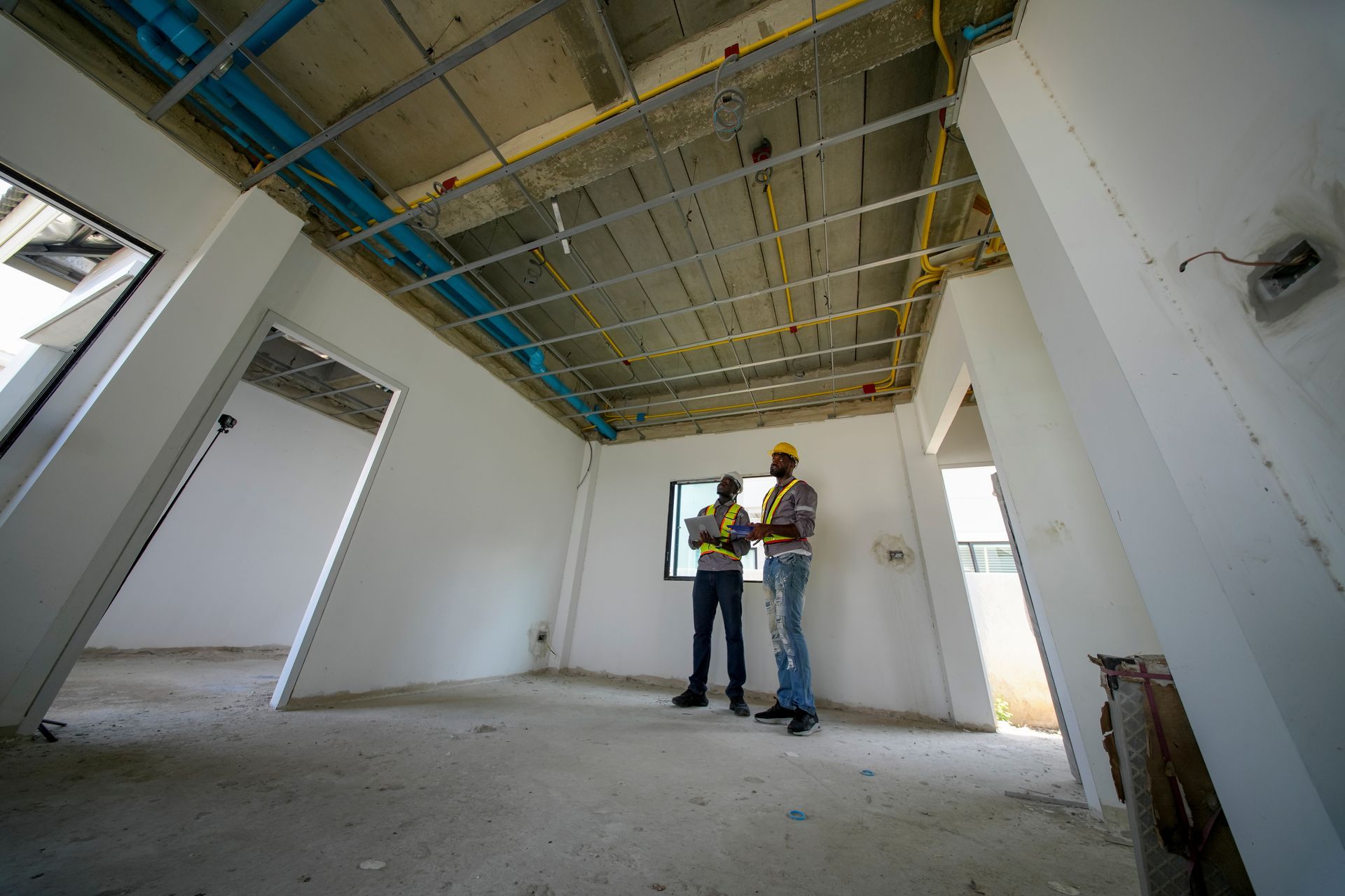 Contractors inspecting wiring and framing during a commercial remodel.