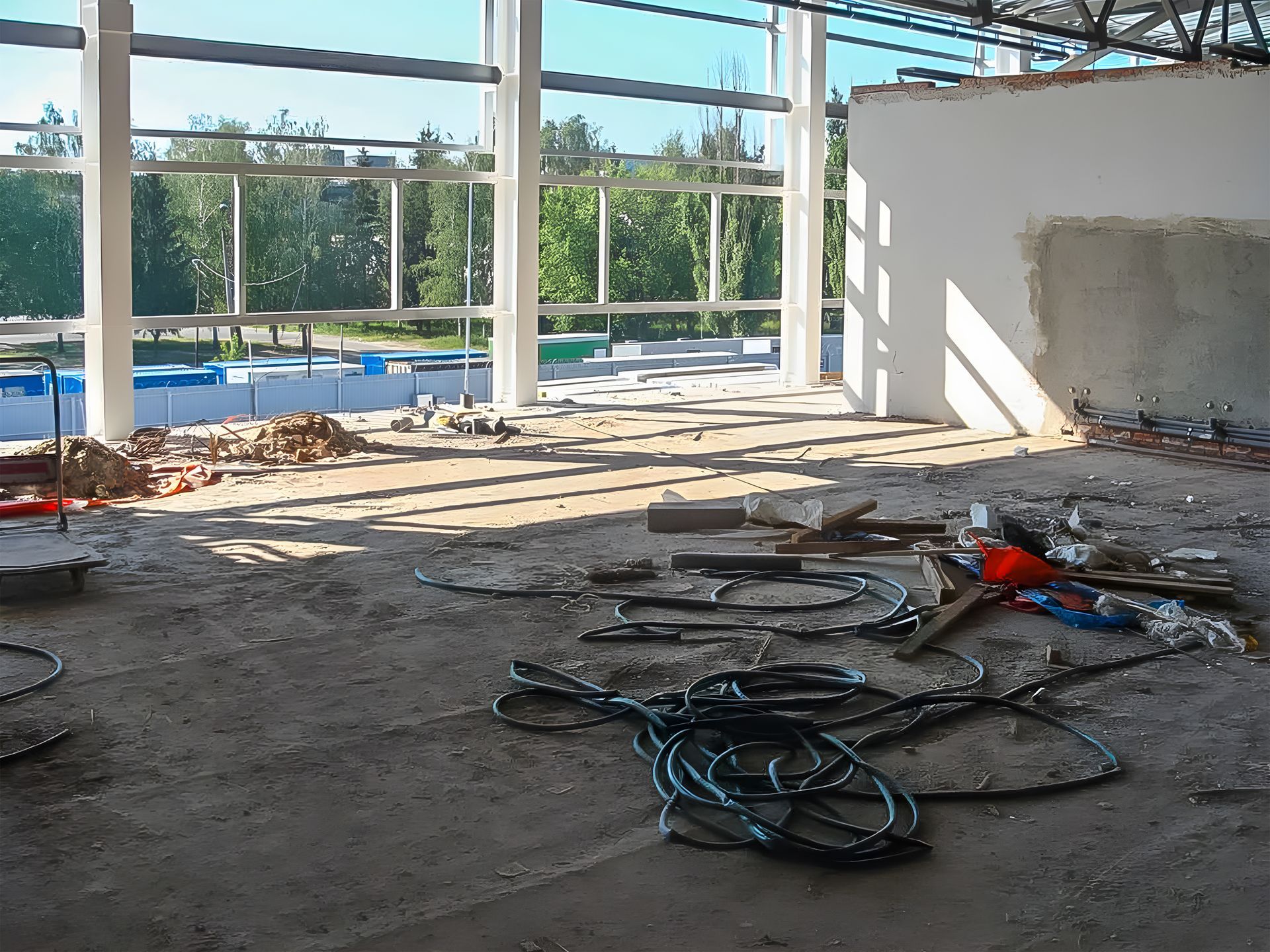 The building interior is under commercial remodel with debris and exposed framing.