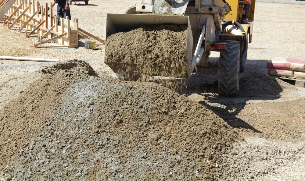 A Bulldozer Is Loading Dirt Into A Pile On A Construction Site — W Wall & Sons In Bloomsbury, QLD