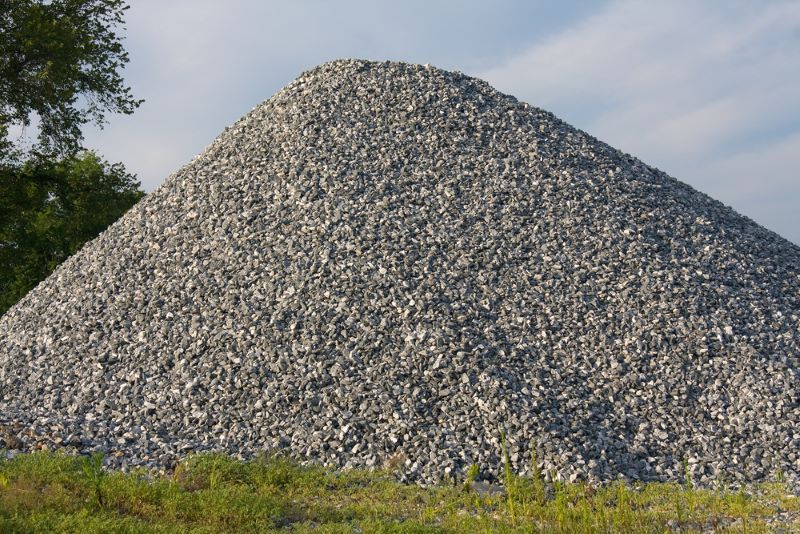 A Large Pile Of Gravel Is Sitting In The Grass — W Wall & Sons In Sarina, QLD