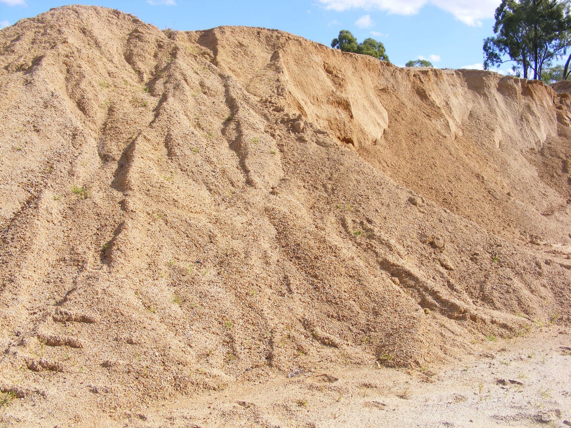 A Bulldozer Is Moving Dirt On A Dirt Road — W Wall & Sons In Bowen, QLD