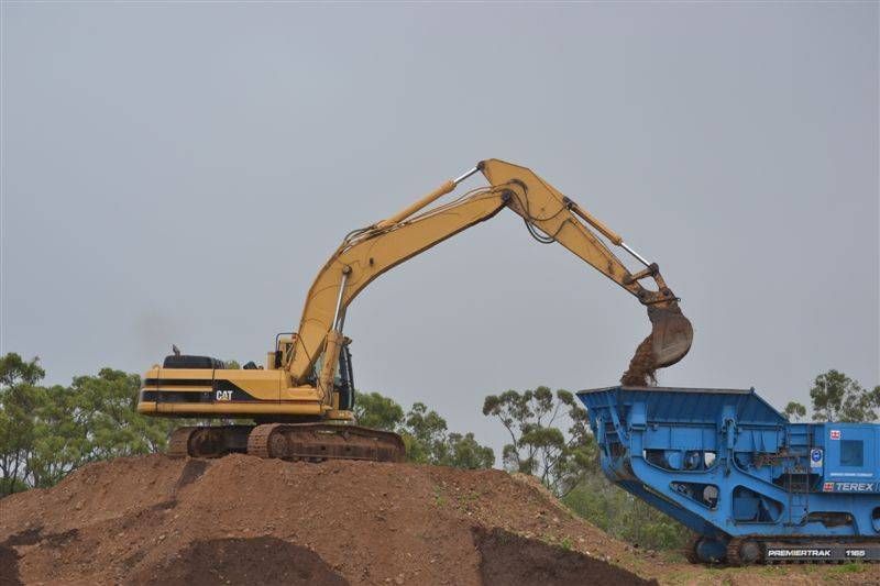 a yellow truck is giving dirt to a blue truck — W Wall & Sons in Nebo, QLD