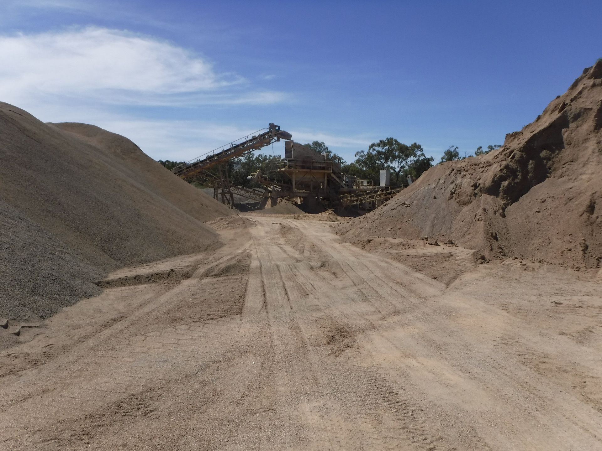 a quarry with a yellow bulldozer and white truck in front — W Wall & Sons in Nebo, QLD