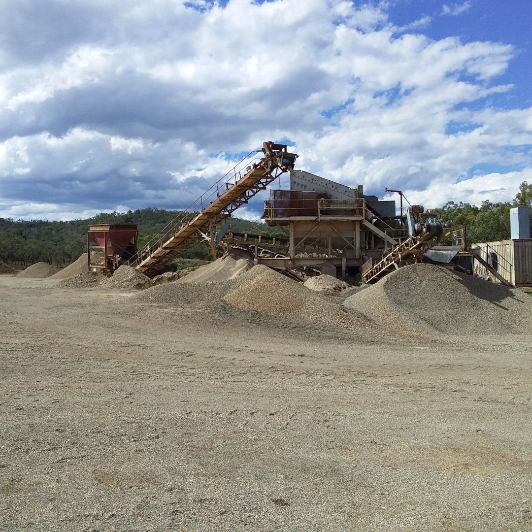 An Excavator Is Loading Rocks Into A Dump Truck In A Quarry — W Wall & Sons In Moranbah, QLD
