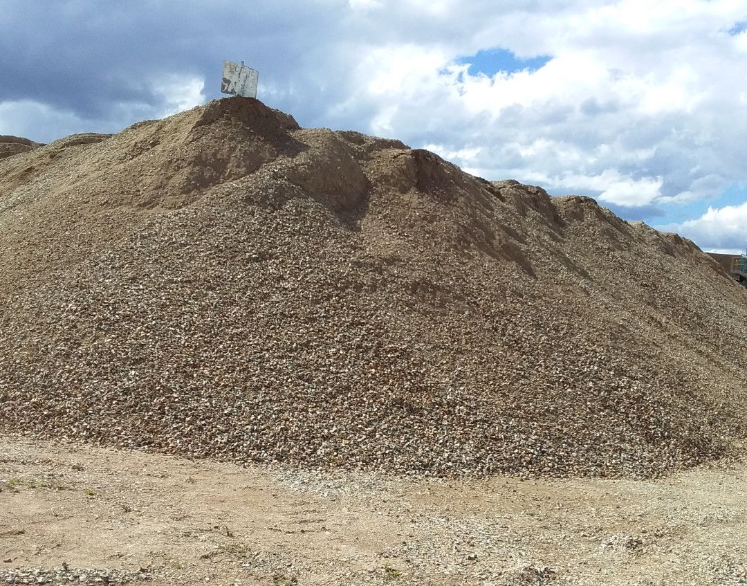 A blue Excavator Is Digging In A Pile Of Dirt — W Wall & Sons In Mackay, QLD